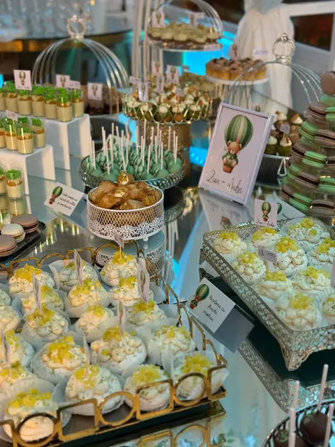 Deserturi în pahare și macarons pe un candy bar de botez