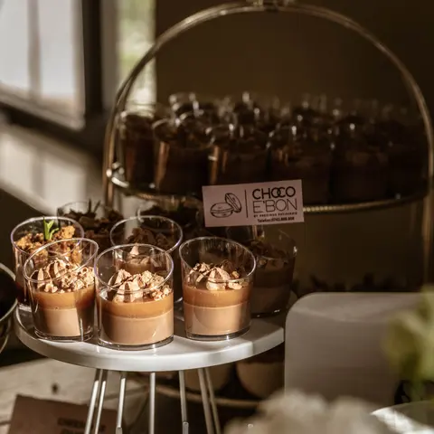 Pahare cu mousse de ciocolată lângă eticheta Choco e'Bon