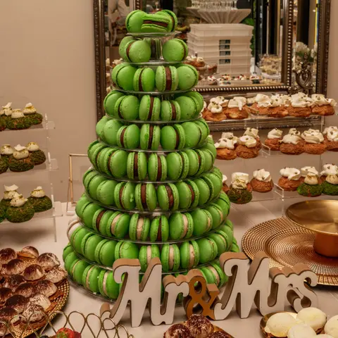 Turn de macarons verzi și litere Mr & Mrs pe un candy bar de nuntă