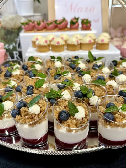 Pahare cu desert cu jeleu de fructe, cremă, crumble și afine